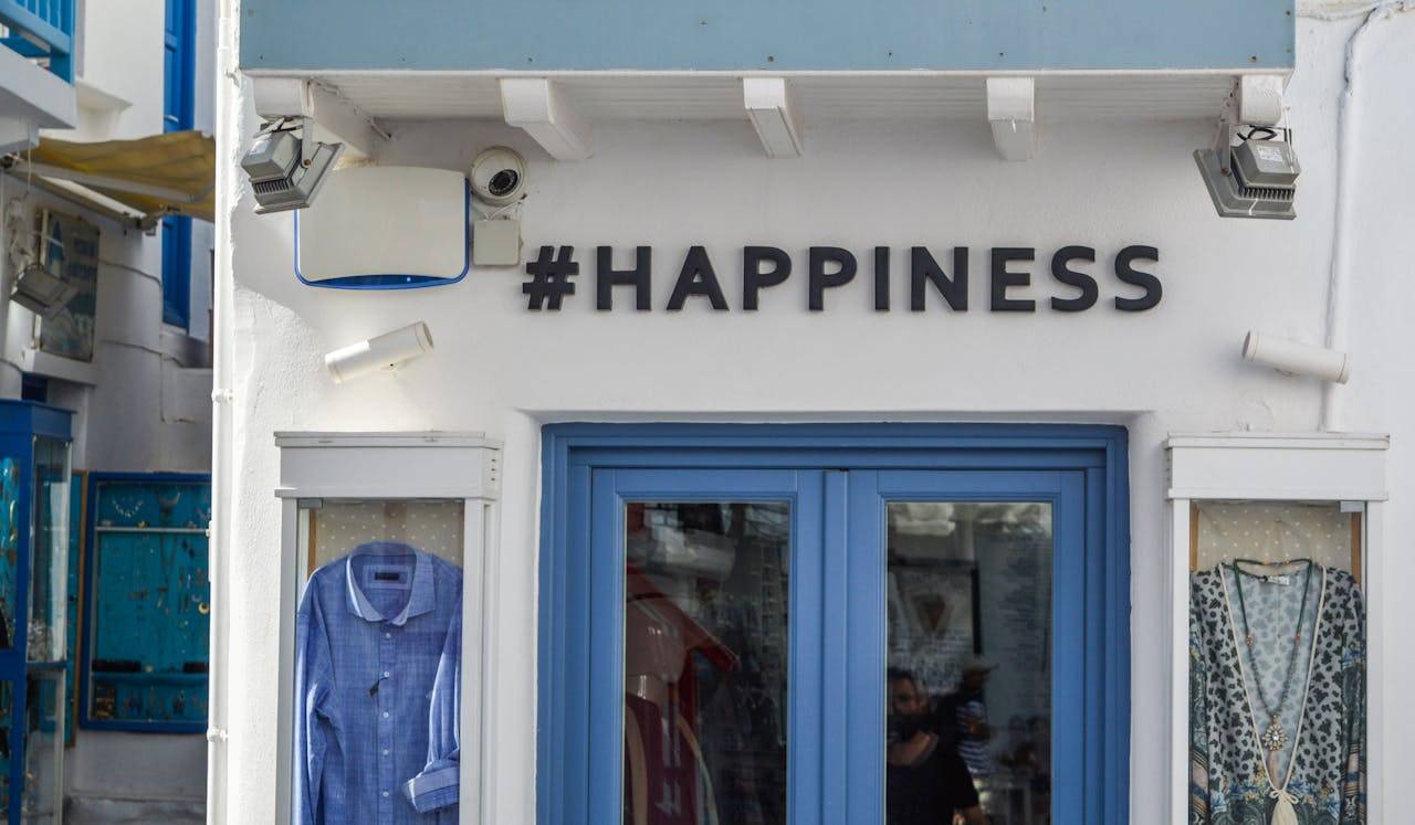 Person smiling while wearing casual clothing with a t-shirt that says "#HAPPINESS".